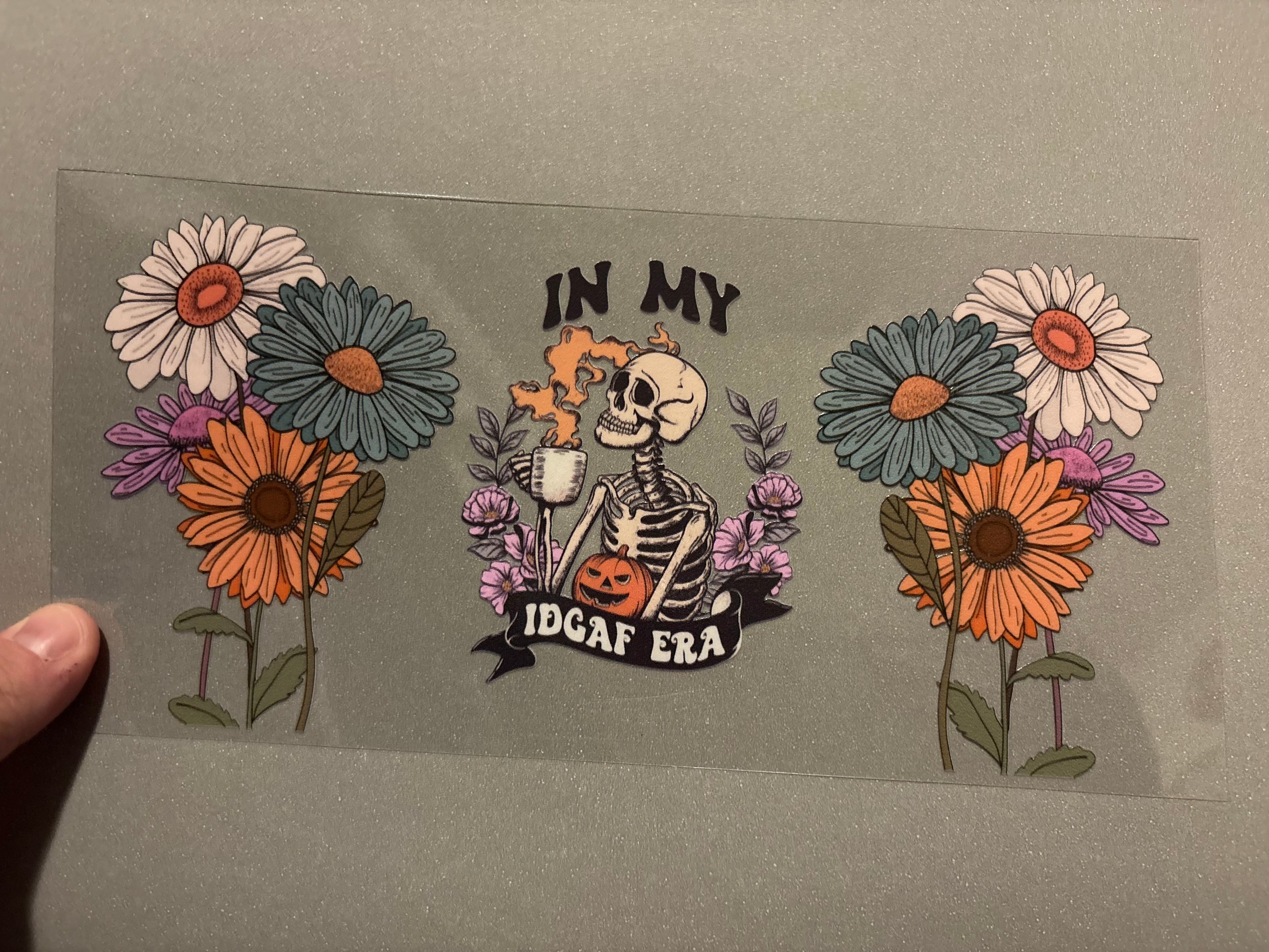 In my idgaf era, skeleton with coffee, tall flowers on each side