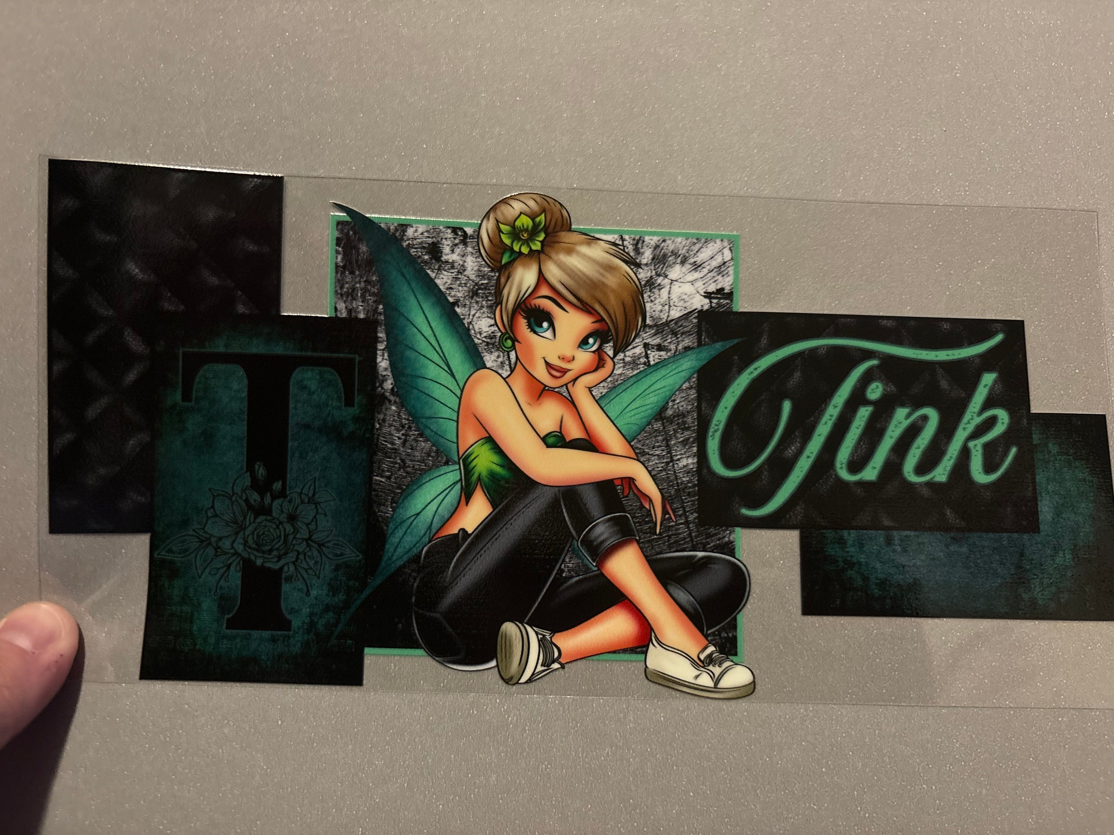 Tink, green shirt, green wings, black pants, white shoes